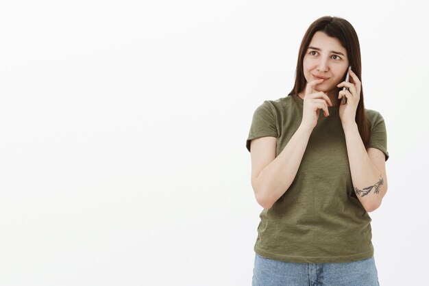 Woman deciding what order talking with administrator on phone holding finger on lips as picking making choice or reservation