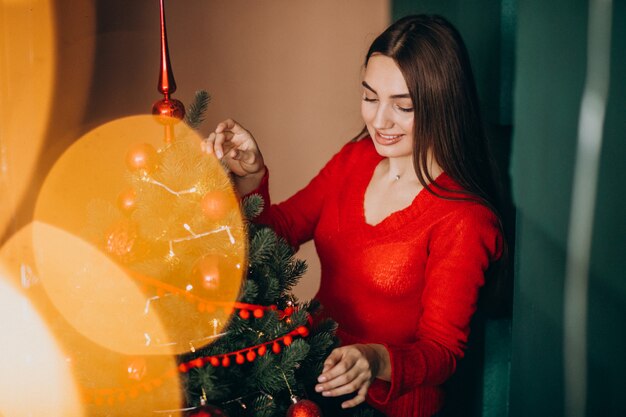 クリスマスにクリスマスツリーを飾る女性