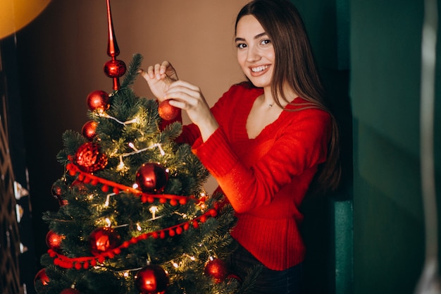 Woman decorating christmas tree on Christmas