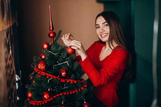 Woman decorating christmas tree on Christmas