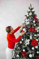 Free photo woman decorating christmas tree