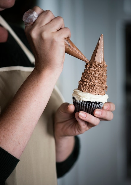 Woman decorating a cupcake