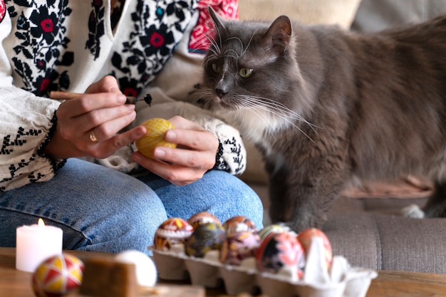 Женщина украшает пасхальные яйца