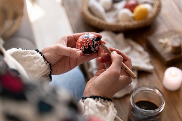 Foto gratuita donna che decora le uova di pasqua