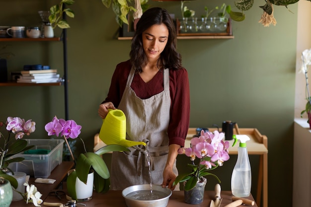 Foto gratuita una donna che decora la sua casa con orchidee