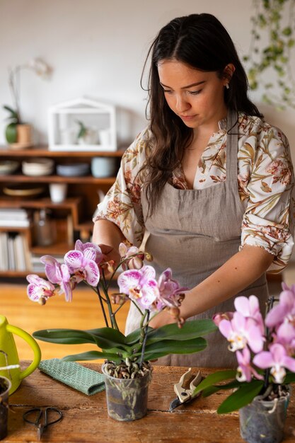 Woman decorating her house with orchids