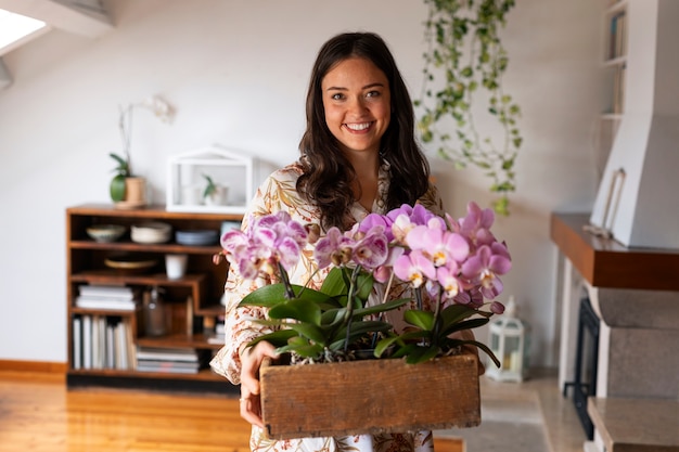 Foto gratuita una donna che decora la sua casa con orchidee