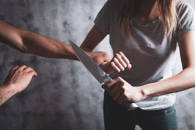 Woman defending herself with a kitchen knife Premium Photo