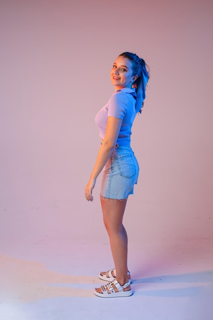 A woman in denim shorts sunglasses in the studio on an interesting beautiful background