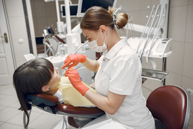 Foto gratuita donna in una poltrona odontoiatrica la ragazza viene esaminata da un dentista la bellezza tratta i suoi denti