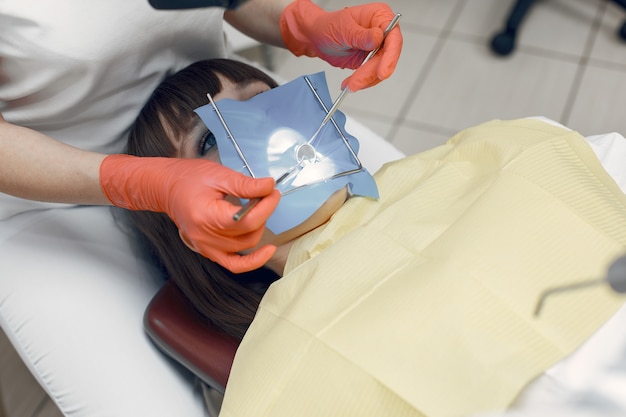 Woman in a dental chair. Girl puts a filling on the tooth. Beauty treats her teeth