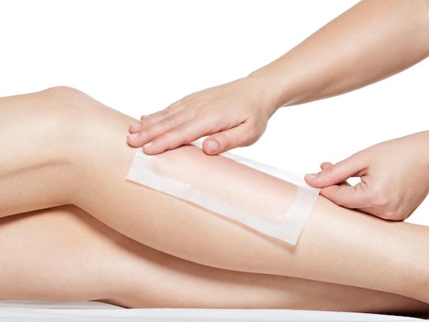 Woman depilating her legs by waxing 