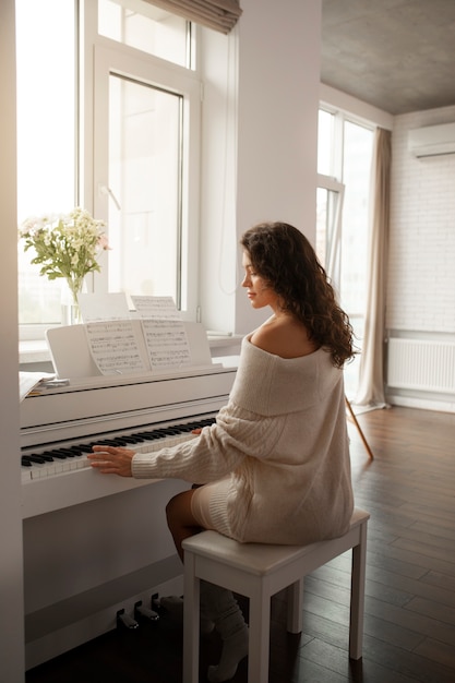 피아노를 연주하여 집에서 디지털 연결을 끊는 여성