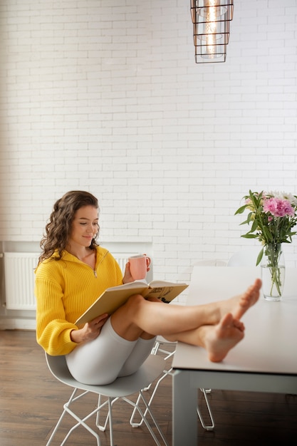 Foto gratuita disconnessione digitale della donna a casa leggendo il libro