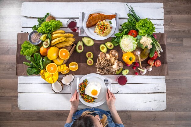 The woman at the dinner table with organic food, the view from the top