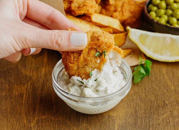 Woman dipping fish in sauce