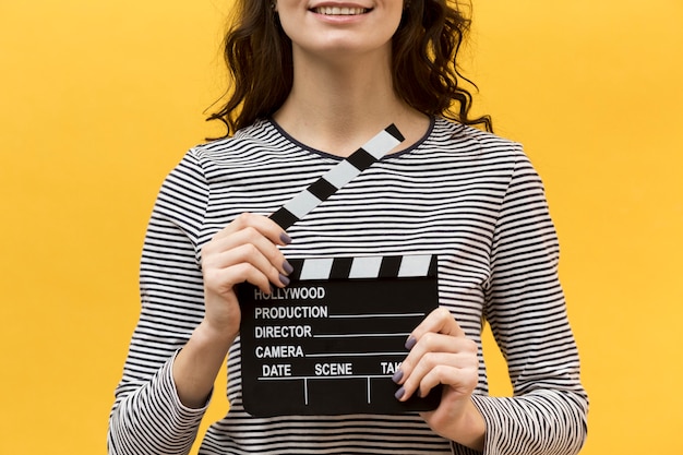 Free photo woman director holding a clapperboard