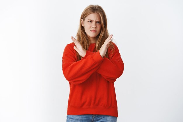 woman dislikes smokers, making cross against body showing negative opinion about bad habits, frowning and making displeased grimace making stop gesture, rejecting and prohibiting nasty actions