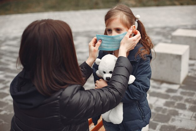 일회용 마스크에 여자는 그녀의 아이에게 인공 호흡기를 착용하도록 가르치고있다