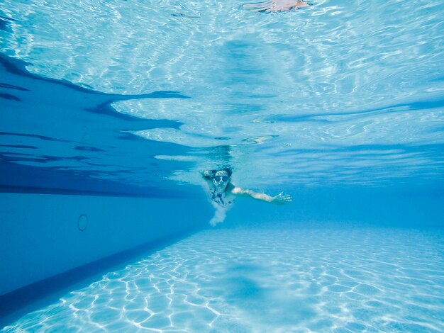 プールでダイビングする女性