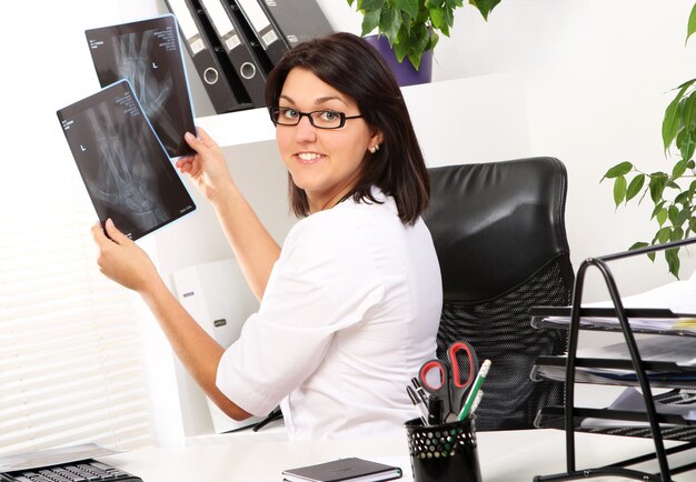 Woman doctor is looking at xray of broken hand