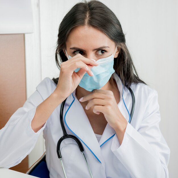 Woman doctor putting on mask