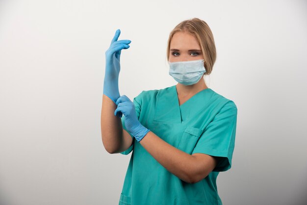 ラテックス手袋と医療用マスクを着用した女性医師。