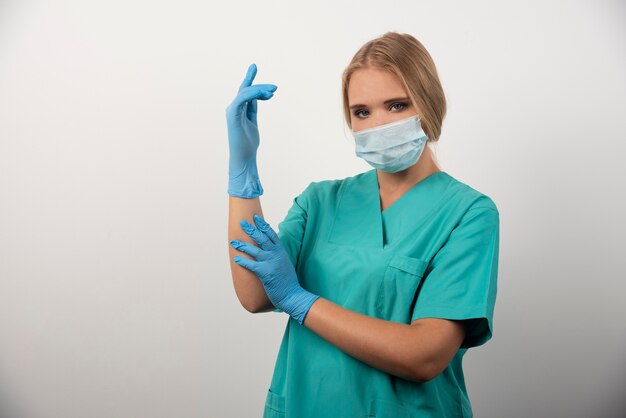 Woman doctor wearing latex gloves and medical mask.