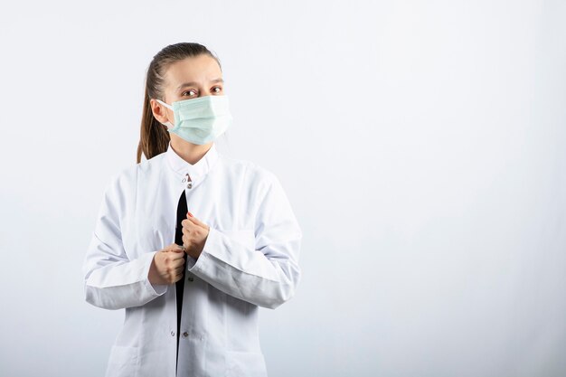 Woman doctor in white uniform wearing a medical mask 
