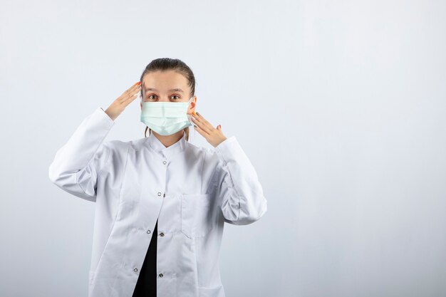 Woman doctor in white uniform wearing a medical mask 