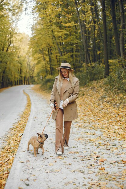 Woman and dog play and have fun in the autumn park