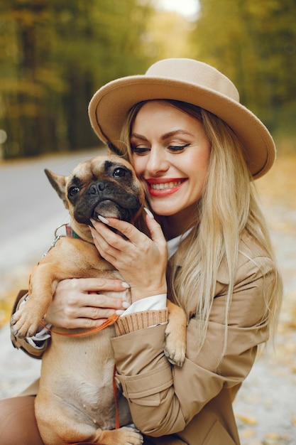 Free photo woman and dog play and have fun in the autumn park