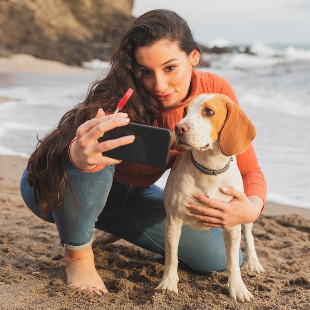 女性と犬のセルフィーを取る