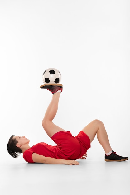 Женщина делает акробатику с футбольным мячом