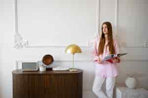 Free photo woman doing daily activities in minimal decorated room