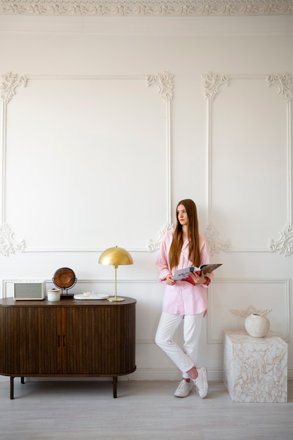 Foto gratuita donna che fa attività quotidiane in una stanza decorata minima