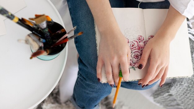 Женщина делает урок рисования со своим телефоном дома