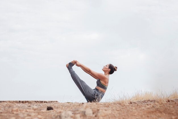 Женщина делает упражнения на открытом воздухе