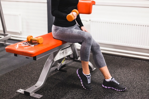 Free photo woman doing exercise with dumbbell at fitness center