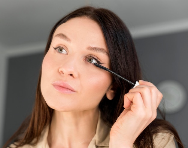 Free photo woman doing eyeliner