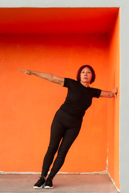 Woman doing fitness exercise while leaning on a wall