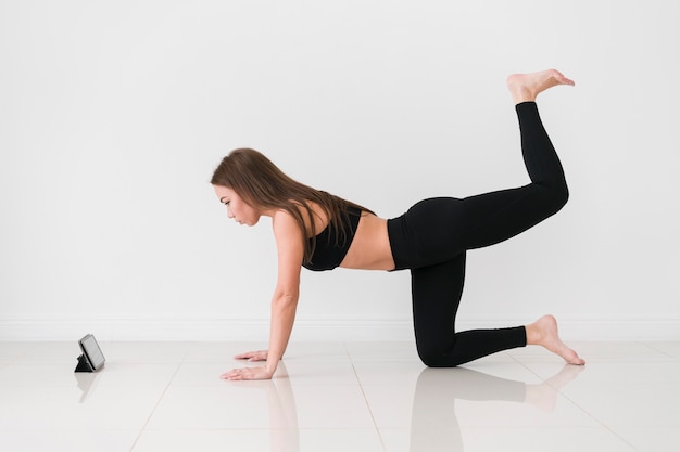 Woman doing fitness exercises from mobile phone