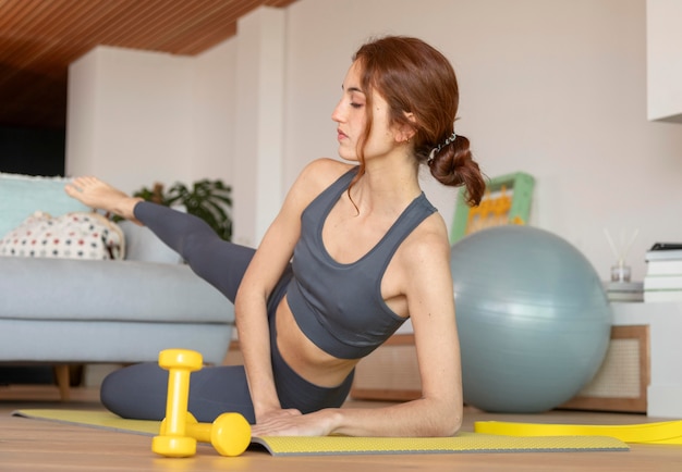 Woman doing fitness at home on mat