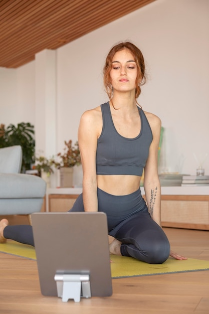 Free photo woman doing fitness at home on mat