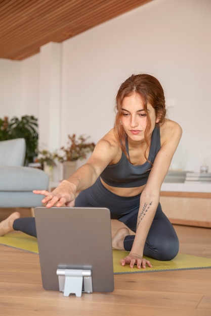 Woman doing fitness at home on mat