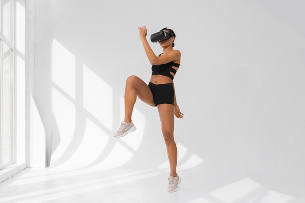 Free photo woman  doing fitness with vr glasses