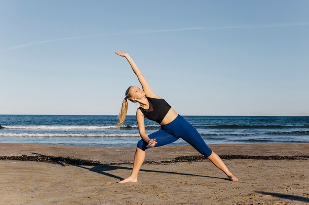 Woman doing gymnastics at the beach
