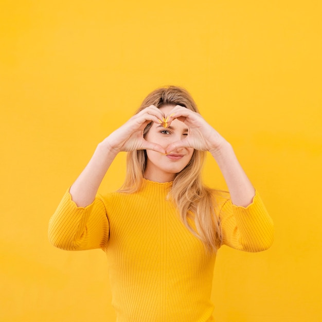 Foto gratuita donna che fa gesto a forma di cuore