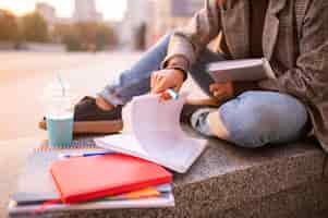 Free photo woman doing homework outdoors in the city