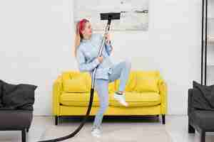 Free photo woman doing house chores with vacuum